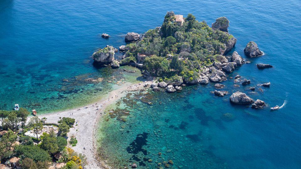 Aerial view of Isola Bella, Taormina, showcasing its crystal-clear waters and lush green landscape